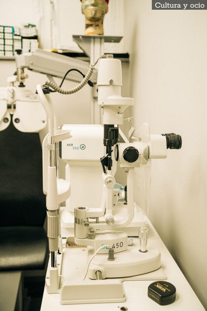 a microscope sitting on top of a table next to a black chair